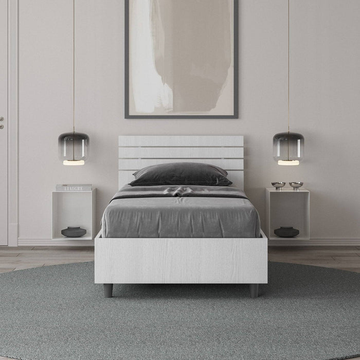 Letto singolo Ankel bianco con contenitore e testata dritta, perfetto per arredamenti minimal. Design salvaspazio per ambienti contemporanei.