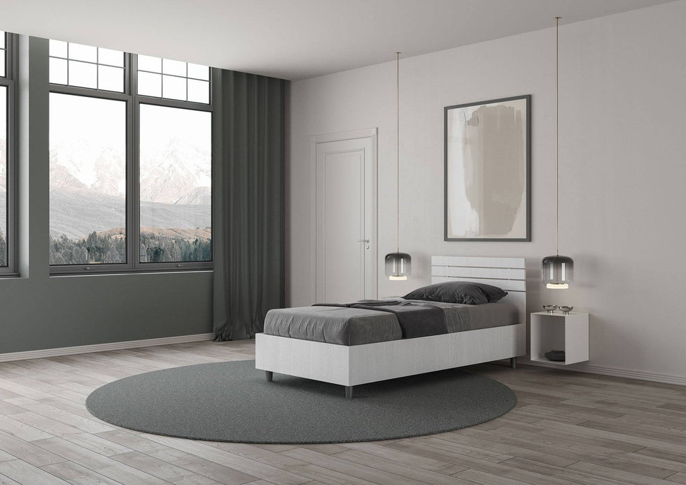 Letto singolo Ankel bianco con testata dritta in una stanza moderna, perfetto per un ambiente accogliente e minimalista.