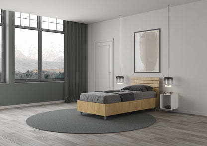 Letto singolo Ankel effetto legno chiaro con contenitore, posizionato in una camera con ampie finestre e vista panoramica.