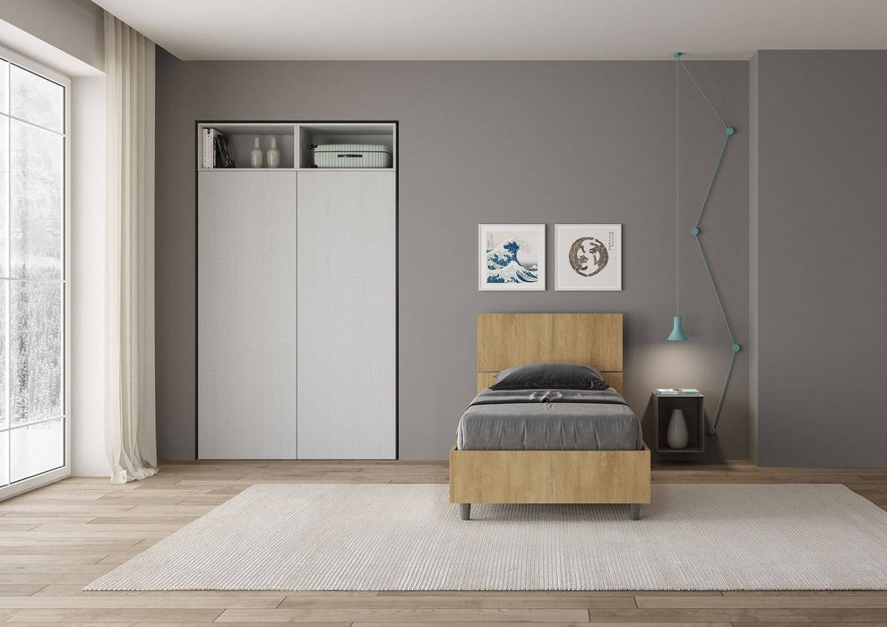 Letto singolo 80x190 Demas effetto legno chiaro con testata inclinata e contenitore, in una camera moderna e funzionale.