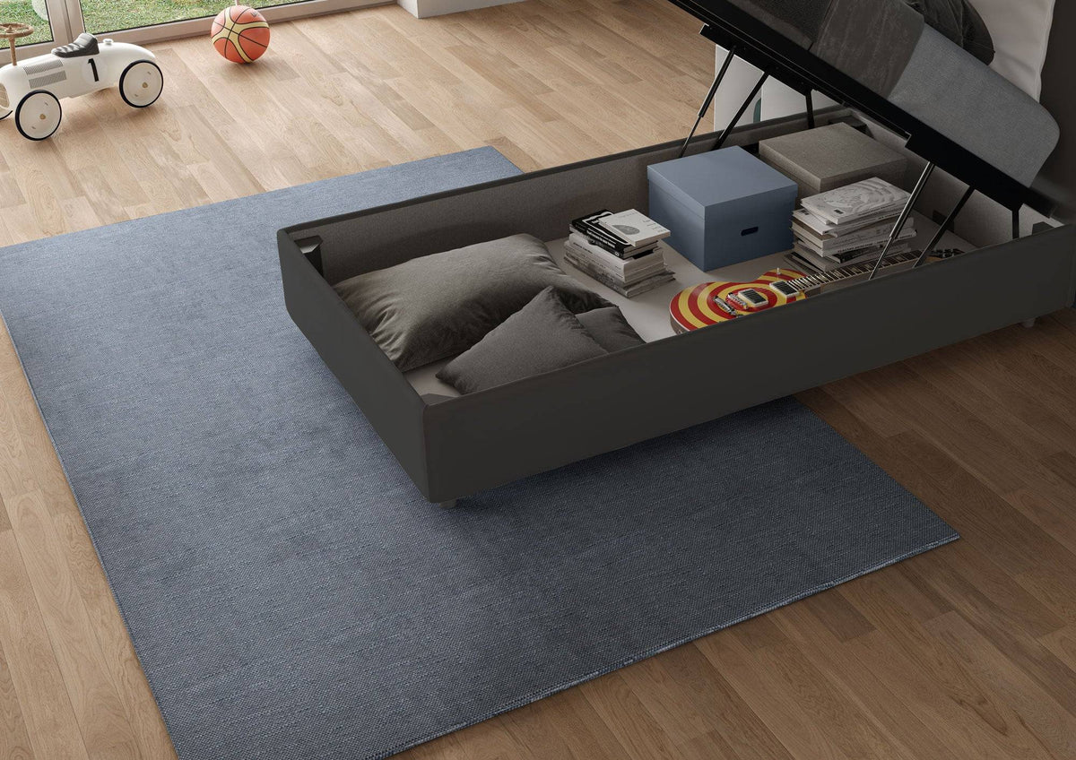 Contenitore del letto singolo Adele 90x200 in microfibra grigio scuro aperto, con spazio per cuscini, libri e giochi. Soluzione salvaspazio funzionale.