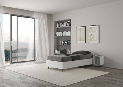 Letto singolo 80x200 Nuamo bianco in una camera moderna con ampie finestre e pavimento in legno chiaro.
