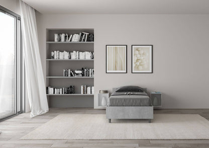 Letto singolo grigio Nuamo 80x200 in una stanza luminosa con libreria integrata e arredamento contemporaneo.
