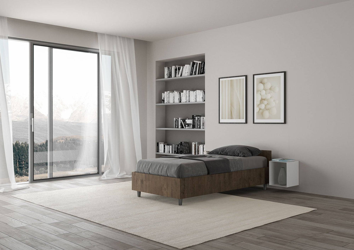 Letto singolo 80x200 Nuamo legno scuro in una camera moderna con ampie finestre e pavimento in legno chiaro.