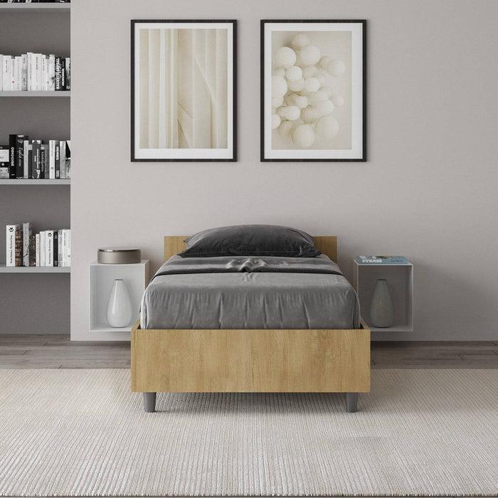 Letto singolo 80x200 Nuamo legno chiaro in una camera moderna, abbinato a comodini sospesi e decorazioni minimaliste.