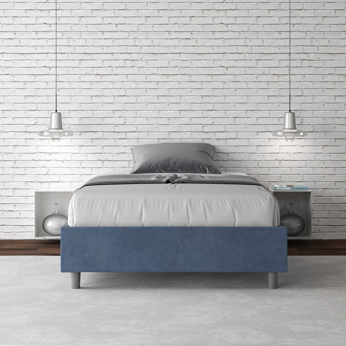 Letto singolo contenitore imbottito 100x210 microfibra Azelia blu navy in camera elegante con parete in mattoni bianchi.