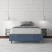 Letto singolo contenitore imbottito 100x210 microfibra Azelia blu navy in camera elegante con parete in mattoni bianchi.
