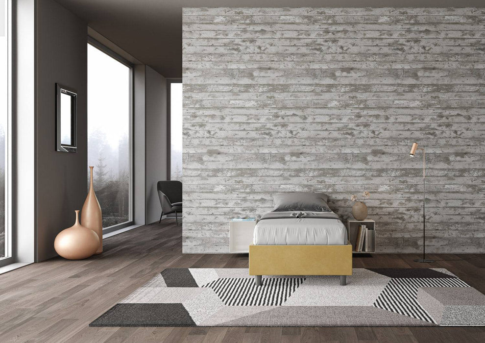 Letto singolo Azelia giallo ocra con contenitore, inserito in camera moderna con pareti effetto legno, perfetto per arredamenti colorati.