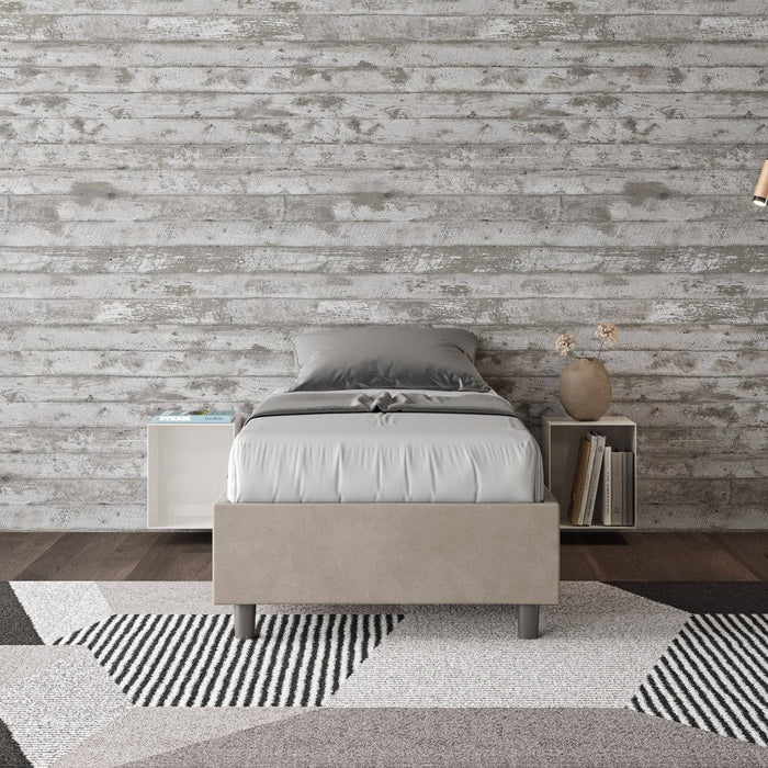 Letto singolo Azelia beige con contenitore, inserito in ambiente moderno con pareti effetto legno, ideale per camere eleganti e ordinate.