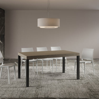 Tavolo allungabile Everyday telaio Antracite con piano marrone in sala da pranzo moderna, abbinato a sedie bianche su tappeto grigio.