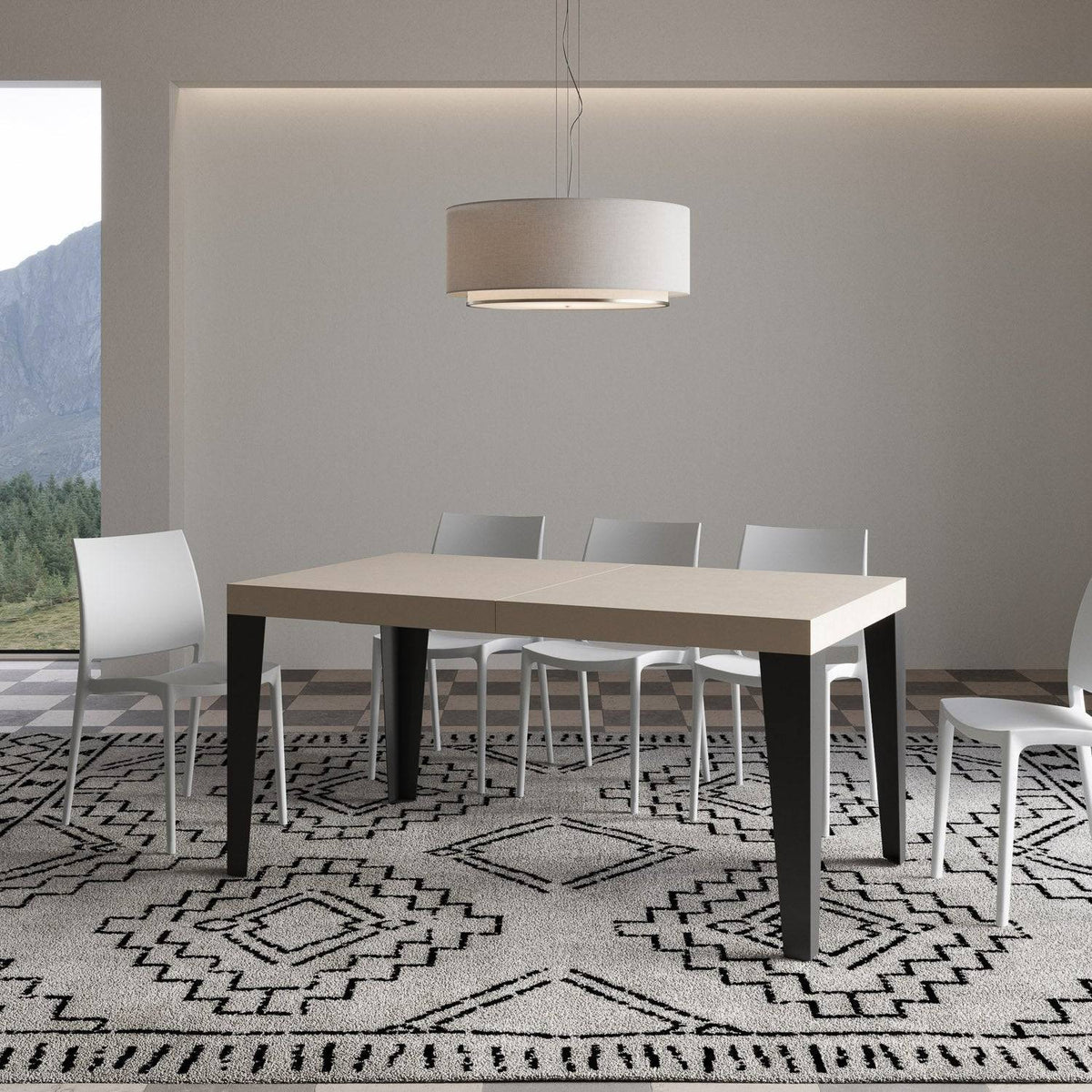 Tavolo Flame allungabile con gambe antracite, in ambiente moderno con tappeto decorativo e sedie bianche.