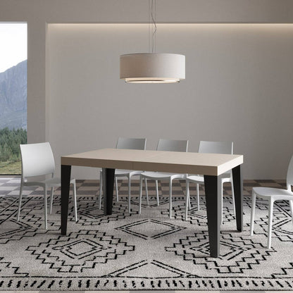 Tavolo Flame allungabile con gambe antracite, in ambiente moderno con tappeto decorativo e sedie bianche.