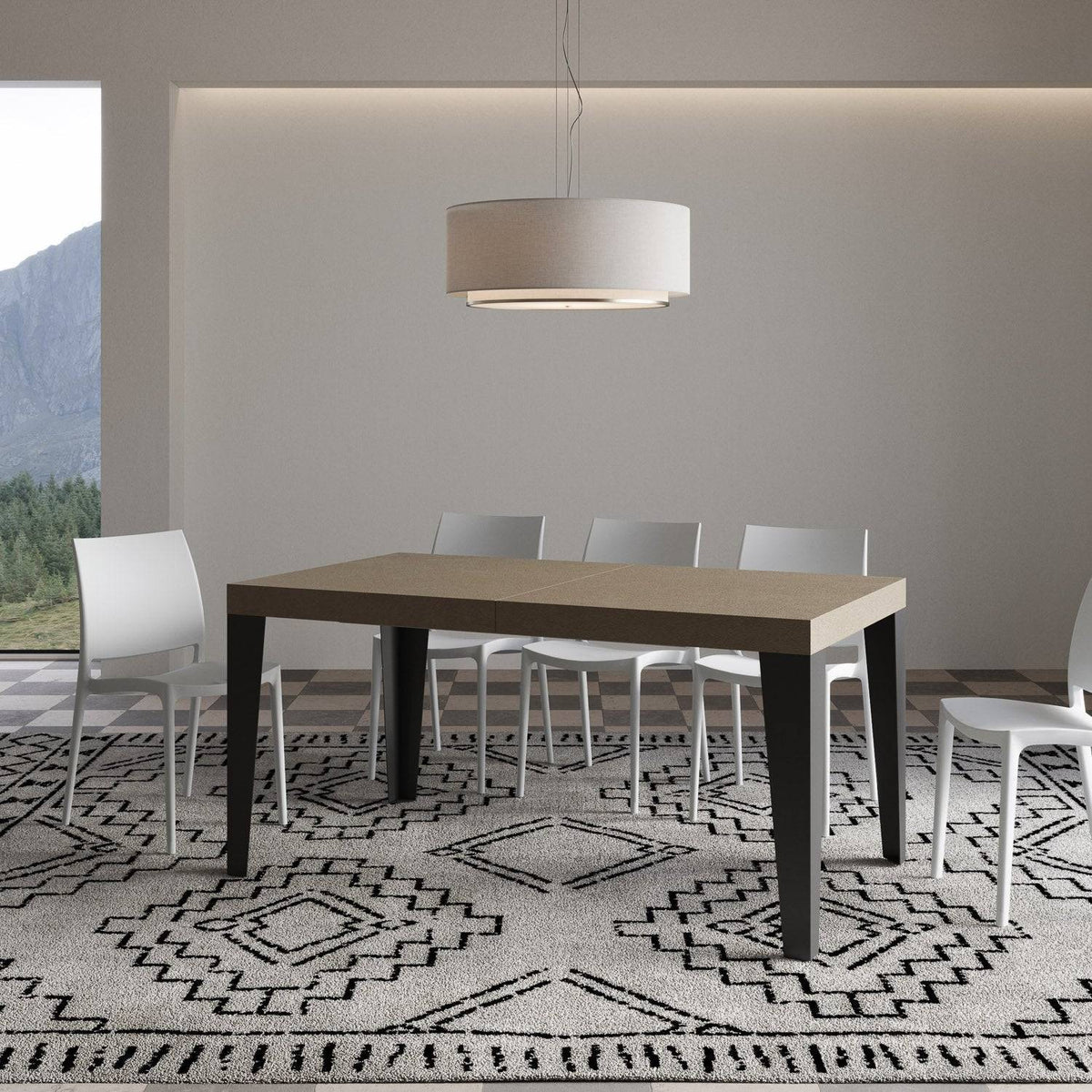Tavolo Flame allungabile con gambe antracite, in ambiente moderno con sedie bianche e tappeto decorativo.
