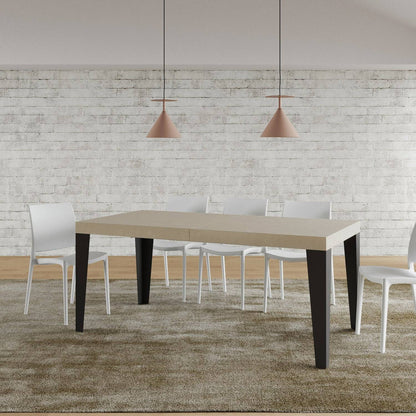 Tavolo Flame allungabile con gambe antracite, in ambiente moderno con sedie bianche e tappeto beige.