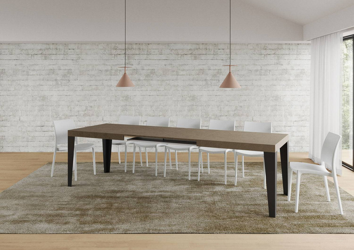 Tavolo Flame allungabile con gambe antracite, completamente esteso per 18 persone in ambiente elegante con tappeto beige.