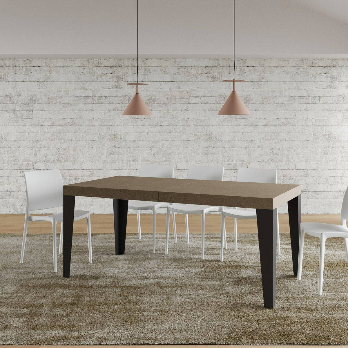 Tavolo Flame allungabile con gambe antracite, in ambiente moderno con parete in mattoni bianchi e sedie bianche.