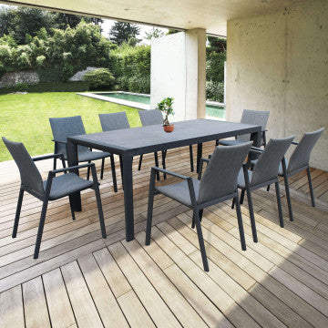 Poltrone Djerba con struttura in alluminio antracite attorno a tavolo da pranzo su patio in legno, ideali per giardini moderni.