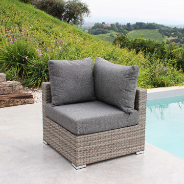 Poltrona angolare Copacabana con struttura in alluminio e wicker grigio, cuscini grigi UV, ideale per esterni, posizionata vicino a una piscina.