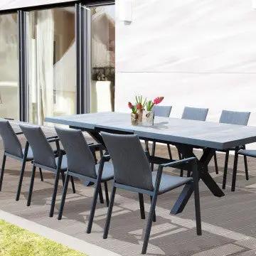 Tavolo Djerba con struttura in alluminio antracite e piano in ceramica effetto legno, arredato con sedie per un ambiente esterno moderno.