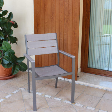Poltrona Cervia da esterno posizionata su terrazzo, struttura in alluminio taupe e seduta in Polywood beige, stile moderno.