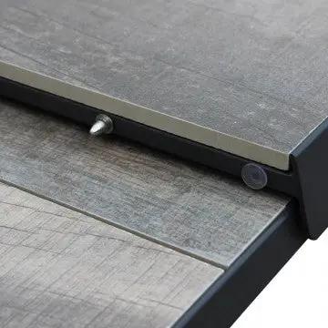 Meccanismo di estensione del tavolo Djerba con struttura in alluminio e piano in ceramica effetto legno, pratico e funzionale.