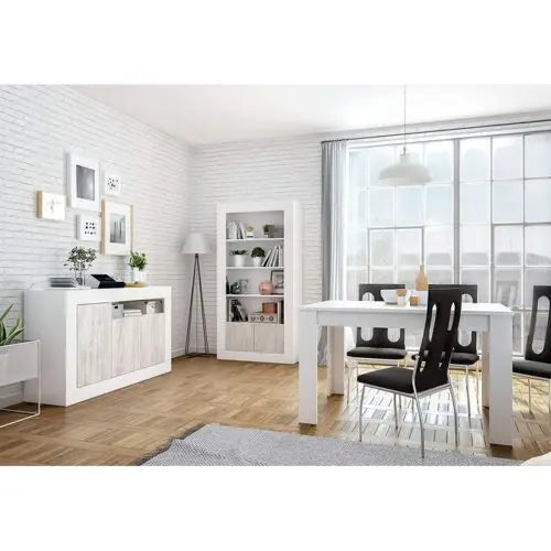 Credenza 3 ante bianco anticato in una sala da pranzo luminosa con tavolo bianco e sedie nere. Design elegante e funzionale per la casa.